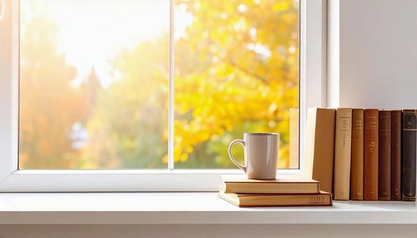 紅葉の見える窓際ディスプレイ　本とカップの写真