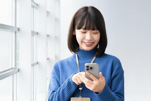 スマホを使う笑顔の女性・ビジネスウーマン スマホを使う笑顔の女性・ビジネスウーマン 女性,スマホ,スマートフォンの写真素材