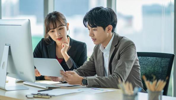 タブレットで打ち合わせするビジネス社員 タブレットで打ち合わせするビジネス社員の写真