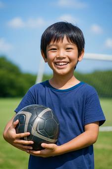 サッカーボールと笑顔の小学生の子供 サッカーボールと笑顔の小学生の子供の写真
