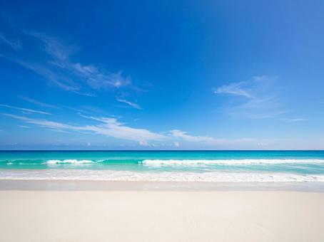 青空と白い砂浜の海辺の写真
