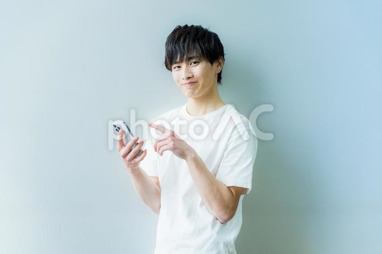 スマホを操作する若い男性 スマホ,笑顔,若いの写真素材