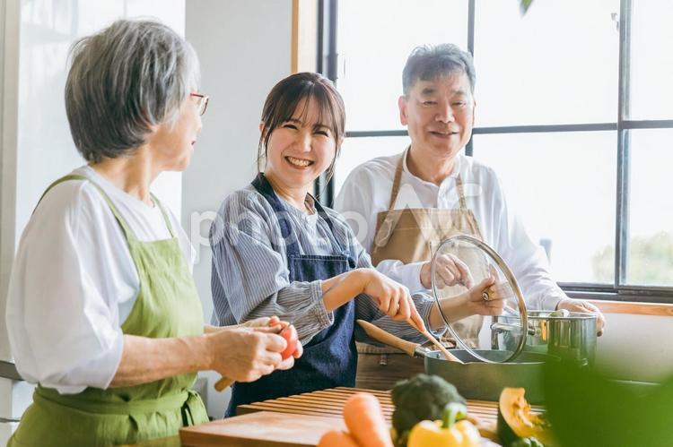 料理する高齢者夫婦と若い女性（料理教室） 帰省,里帰り,孫の写真素材