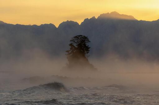 黄金色に染まり始める雨晴海岸の気嵐 雨晴海岸,気嵐,女岩の写真素材