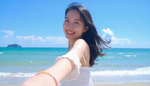 海岸デート　手を引く女性の写真