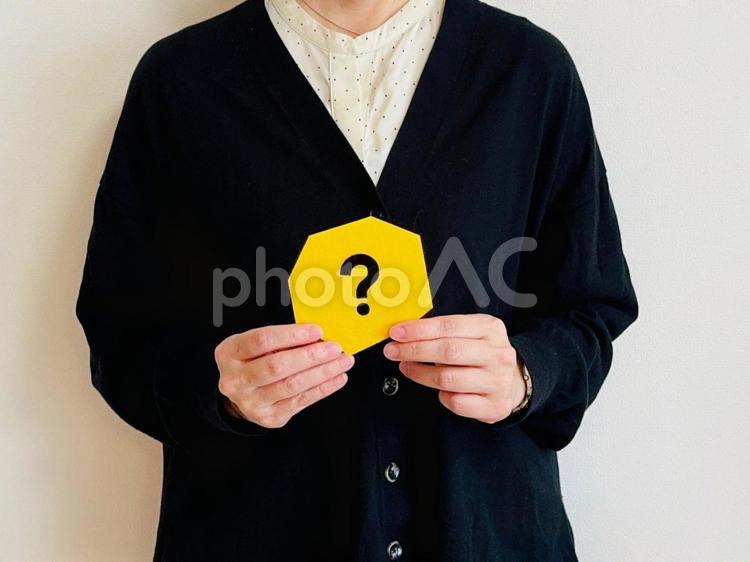 黄色いクエスチョンマークを持った女性 なんで,なぜ,どうしての写真素材