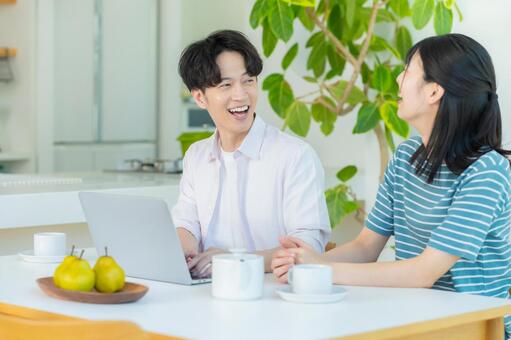 パソコンを見るカップル ノートパソコン,笑顔,カップルの写真素材