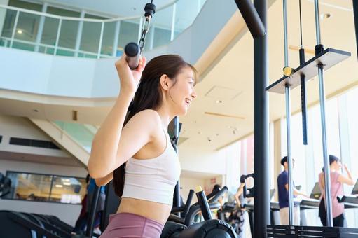 ジムで笑顔でトレーニングする女性 トレーニング,女性,筋トレの写真素材