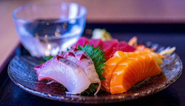 ガラスの皿に盛られた刺し身と日本酒 ガラスの皿に盛られた刺し身と日本酒の写真