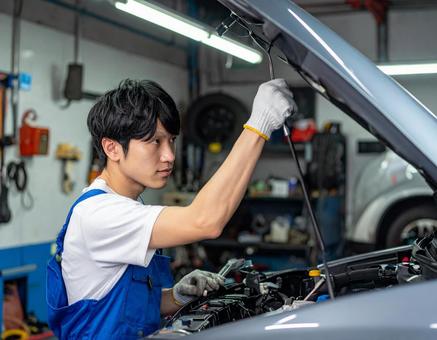 自動車工場でエンジン整備する男性スタッフの写真