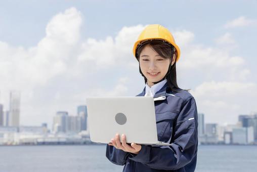 Young woman in work clothes using a laptop, JPG
