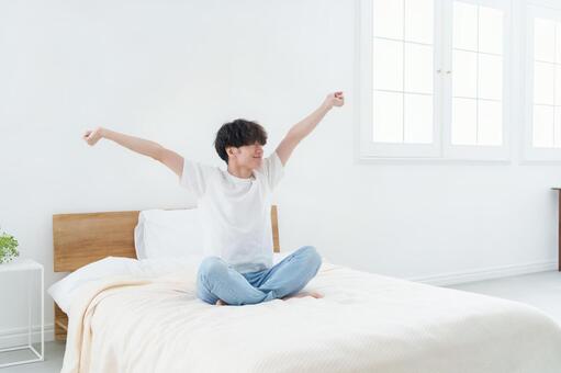 ベッドでストレッチをする男性 男性,ベッド,寝室の写真素材
