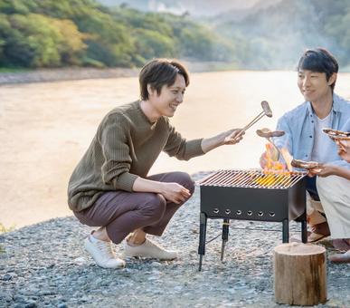 バーベキューを楽しむ男性2人 バーベキューを楽しむ男性2人の写真