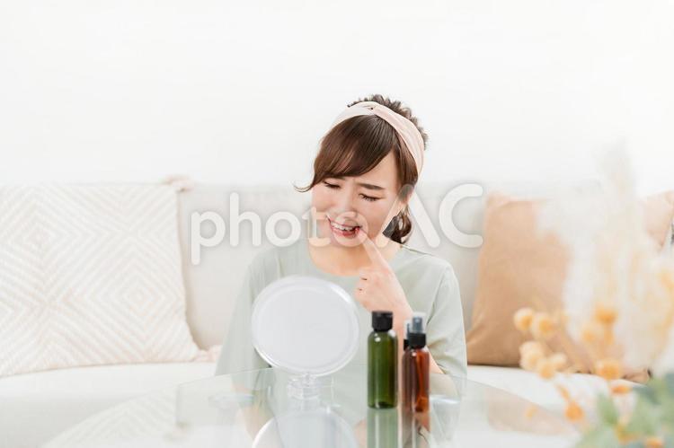 家で鏡を見ながら奥歯・口内炎で悩む女性 奥歯,親知らず,虫歯の写真素材