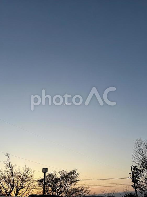 夕暮れのひこうき雲 夕陽,夕方,夕焼けの写真素材
