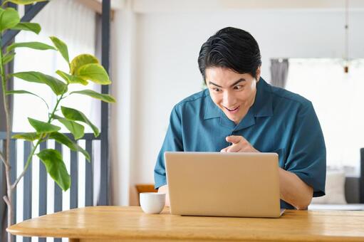 ノートパソコンを見て大喜びする男性 男性,投資,喜ぶの写真素材