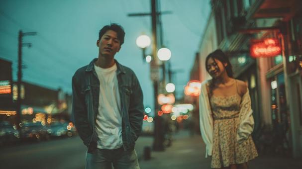 夜の街で佇む若い男女 夜の街で佇む若い男女の写真