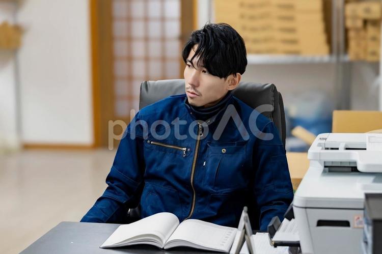 椅子に座って休憩する作業服の男性 ビジネス,ビジネスマン,男の写真素材