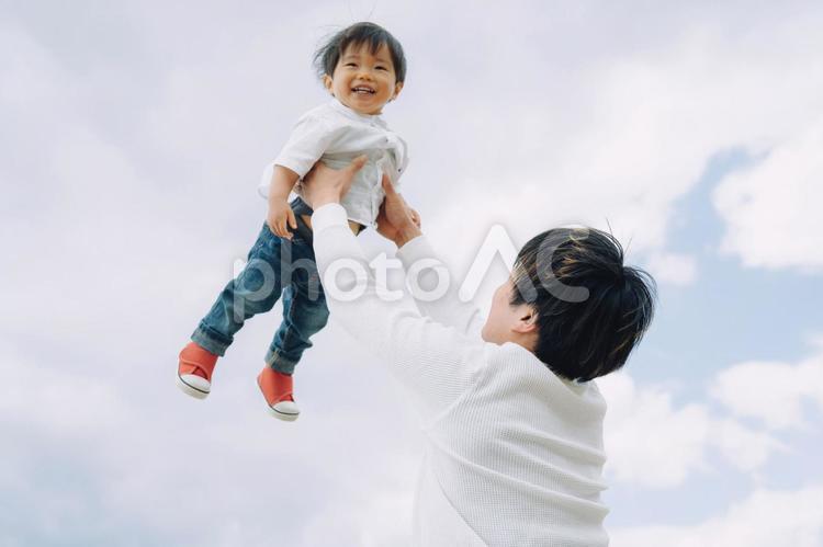 高い高いされる子供とパパ（空） 親子,家族,イクメンの写真素材