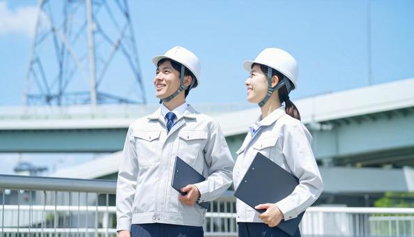 建設作業員男女2人が空を見上げる横顔 建設作業員男女2人が空を見上げる横顔の写真