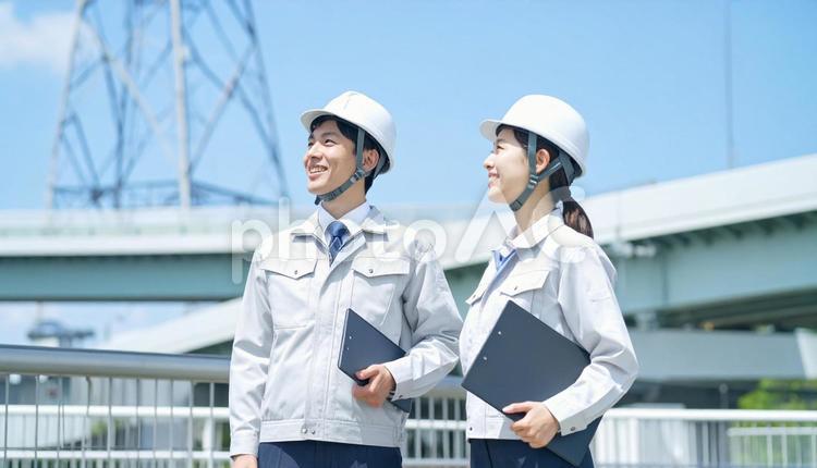 建設作業員男女2人が空を見上げる横顔 作業員,技術者,まちづくりの写真素材