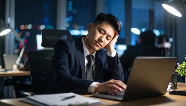仕事中に居眠りしているビジネスマンの写真