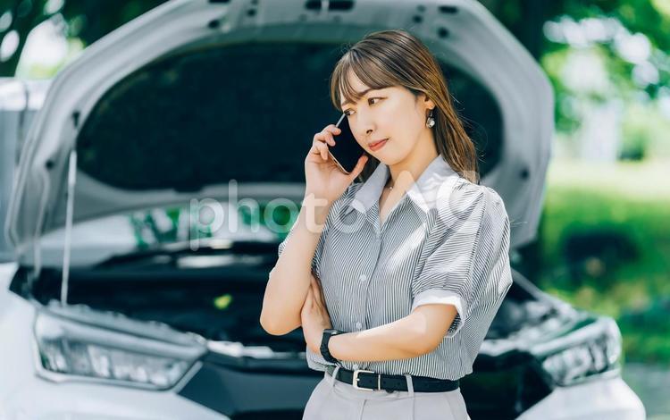 車が故障してロードサービスに連絡する女性 車,故障,女性の写真素材