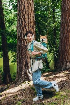 大きな木の前で犬を背負う男性 男性,外国人,犬の写真素材