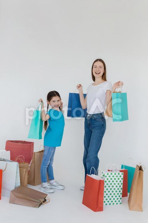 紙袋を持って遠くを見る親子（縦）３ 女性,女の子,親子の写真素材