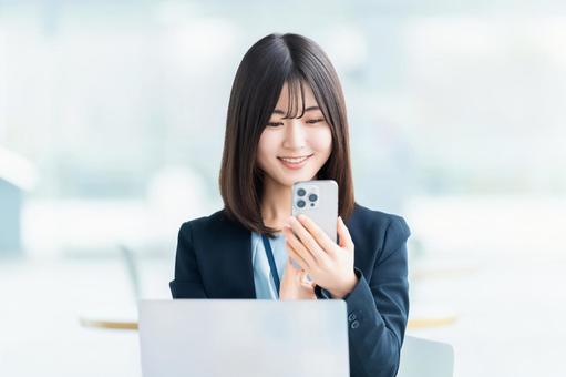 スマホを使う笑顔の女性・ビジネスウーマン 女性,スマホ,スマートフォンの写真素材