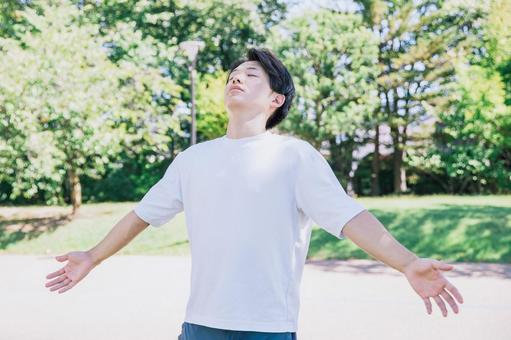 新緑の中深呼吸をする男性 新緑の中深呼吸をする男性 深呼吸,呼吸,酸素の写真素材