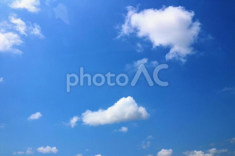 暑い日差しの中、青い空に浮かぶ白い雲　空画像 空,光,青空の写真素材
