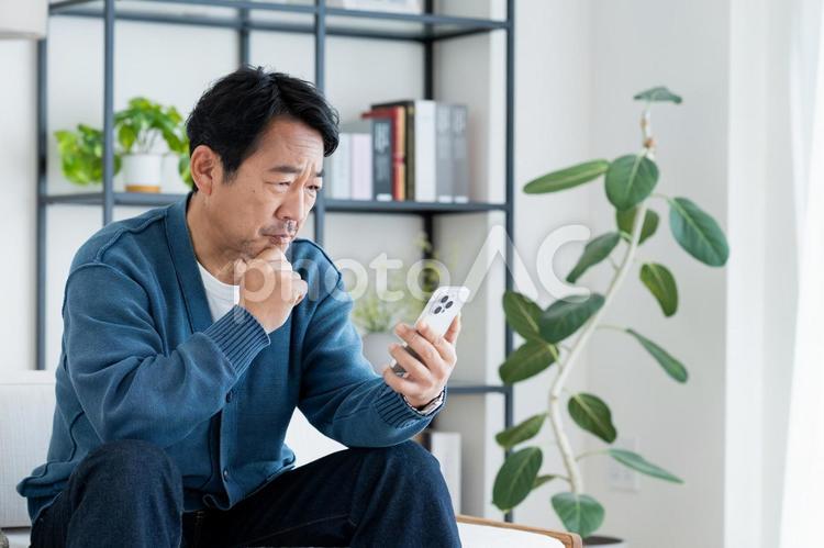 スマホで悩むミドルの男性 スマホで悩むミドルの男性 スマホ,悩む,ミドルの写真素材