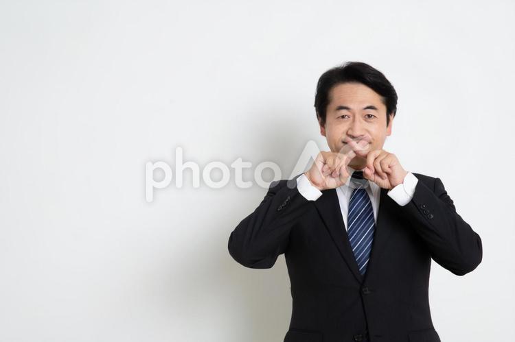口の近くで指を交差している中年のサラリーマン男性（コピースペース） 中年,上司,会社員の写真素材