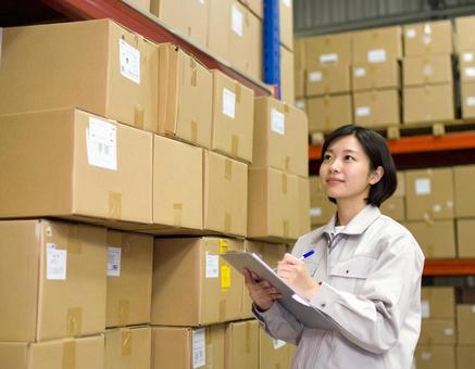 倉庫で在庫をチェックする女性作業員 倉庫で在庫をチェックする女性作業員の写真