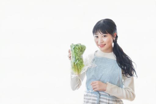 レタスを持つ若い女性 レタスを持つ若い女性 栄養,節約,健康の写真素材