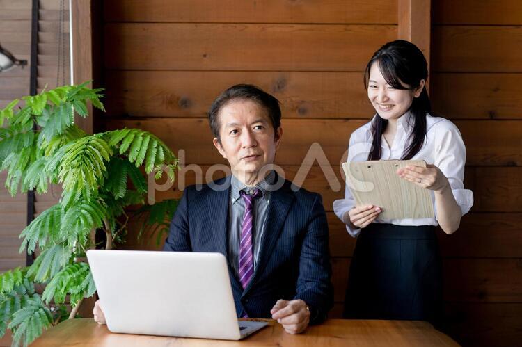 デスクに座る中高年のビジネスマンとビジネスウーマン 経営者,秘書,社長の写真素材