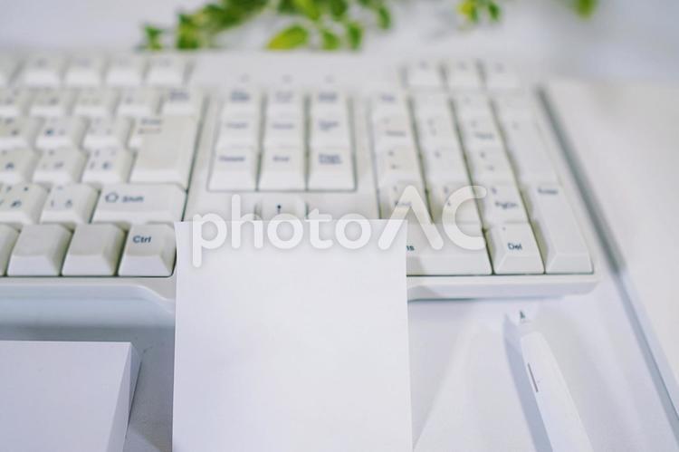 作業中のデスク、白い付箋にメモを書く 重要,文字,メッセージの写真素材