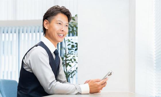 スマホを使う笑顔の男性ビジネスマン スマホを使う笑顔の男性ビジネスマン 男性,スマホ,スマートフォンの写真素材