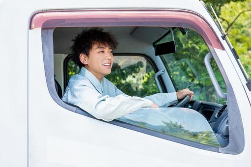 爽やかに大型トラックを乗る作業服の男性 爽やかに大型トラックを乗る作業服の男性 トラック,トラック男性,ドライバーの写真素材