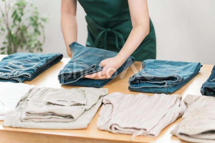 洋服屋・アパレルショップで服を畳む女性 服,商品,品出しの写真素材
