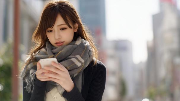 スマホを操作する女性 スマホを操作する女性の写真