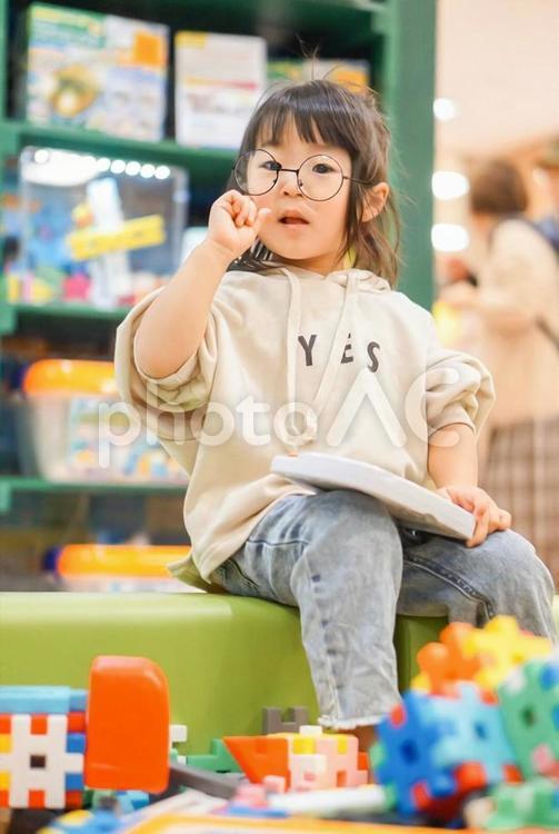 座っている眼鏡の女の子 柄物,女の子,幼児の写真素材