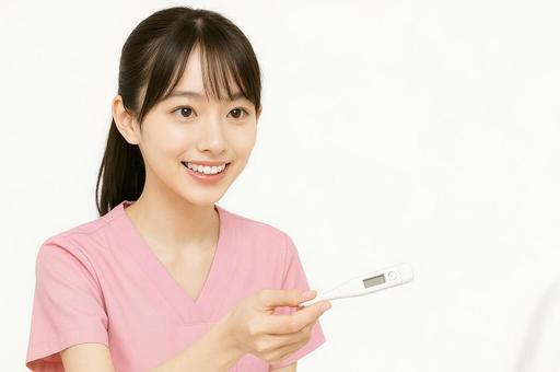 体温計を差し出す看護師 体温計を差し出す看護師の写真