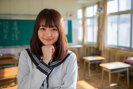 セーラー服の女子学生の教室での微笑み セーラー服の女子学生の教室での微笑みの写真
