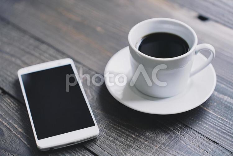 スマートフォンとコーヒー 屋内,木目,シンプルの写真素材