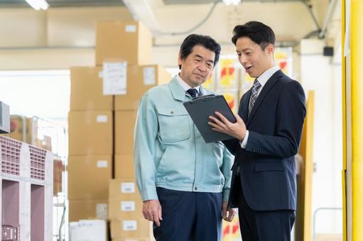 倉庫で商談をする経営者とビジネスマン 倉庫で商談をする経営者とビジネスマン 会議,倉庫,工場の写真素材