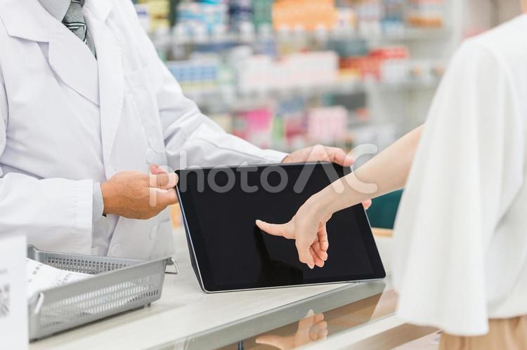 薬局でタブレットを使って説明する薬剤師 薬剤師,タブレット,電子薬歴の写真素材