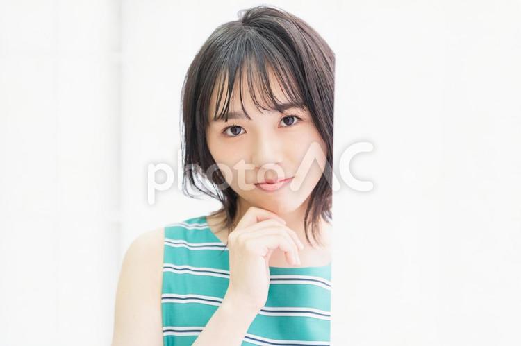 窓際に立ってこちらを見つめている若い女性 窓際,立つ,若いの写真素材