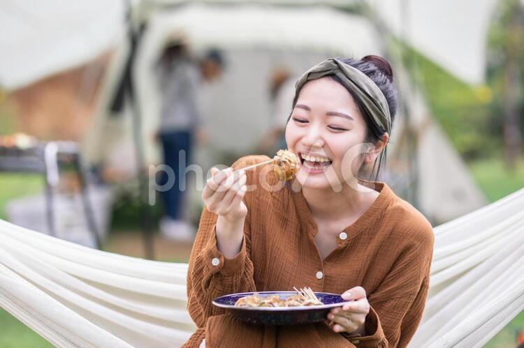 キャンプでたこ焼きを食べる女性 キャンプ,食べる,女性の写真素材